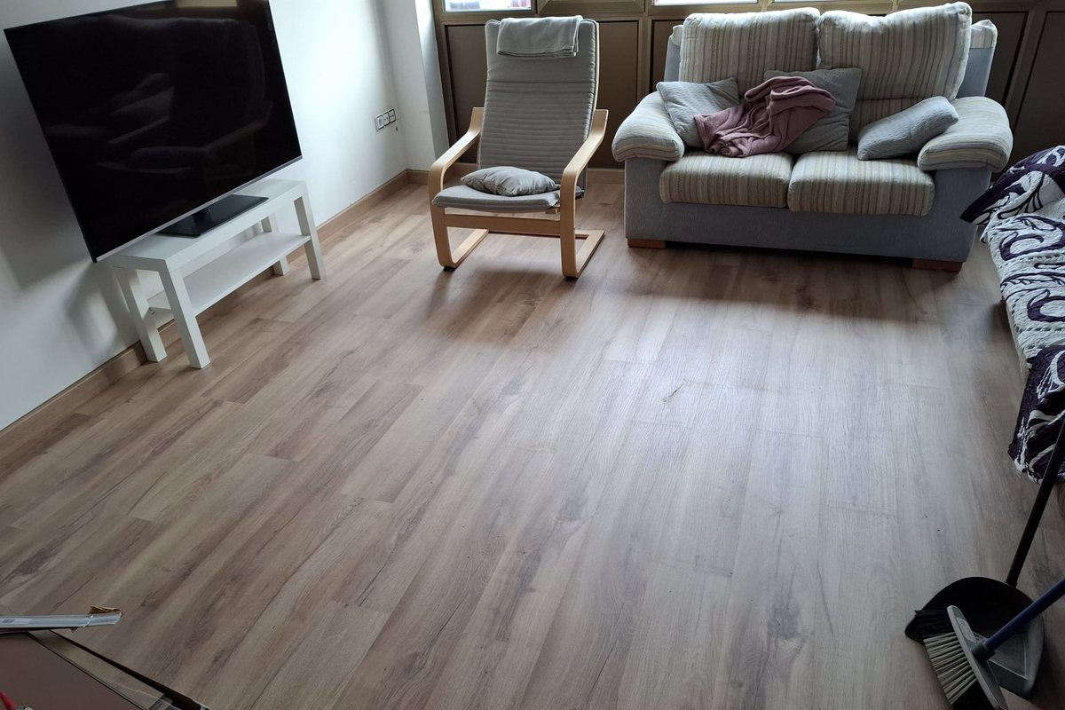 Salón con suelo laminado en tono roble claro y rodapié a juego